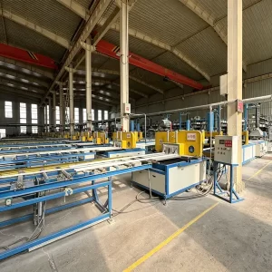 FRP pultrusion production line at Mingchi factory, automated fiberglass manufacturing machinery, industrial workshop with overhead cranes