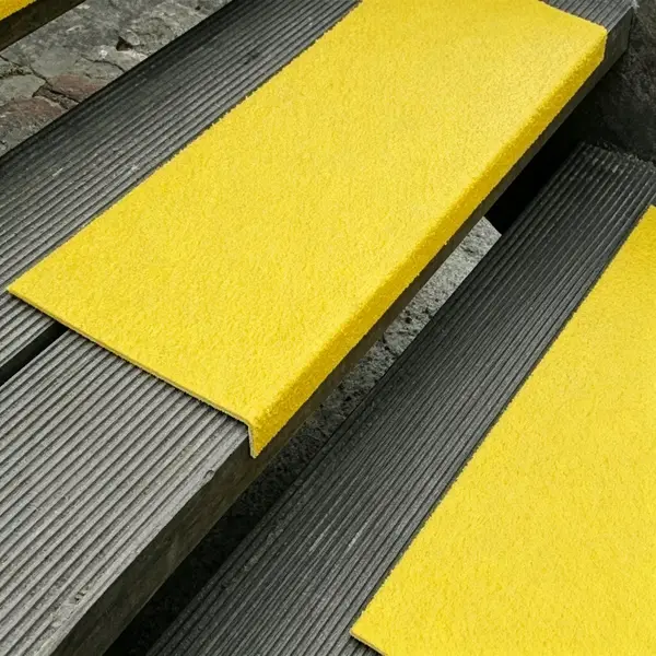 Close-up of yellow fiberglass anti-slip stair nosing installed on metal steps