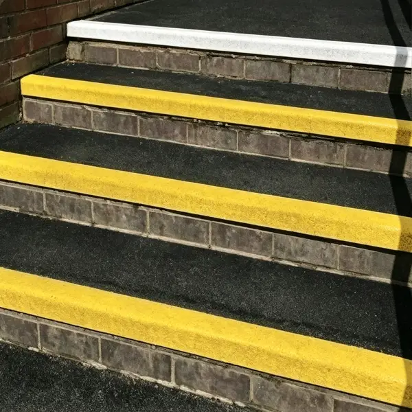 Close-up of yellow fiberglass anti-slip stair nosing installed on metal steps