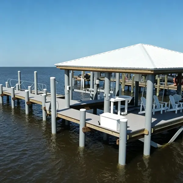 Gray fiberglass round tube pilings supporting coastal dock and boat lift structure, saltwater-resistant FRP round pipe for marine construction