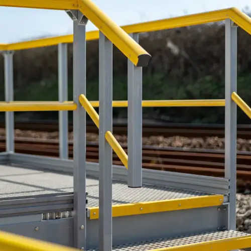 Fiberglass handrail and stair platform with yellow rails and gray support profiles