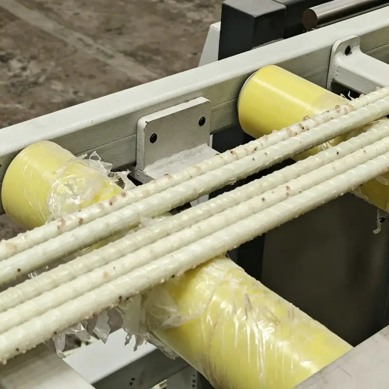 FRP rebar production process: raw material coils and finished product on manufacturing line