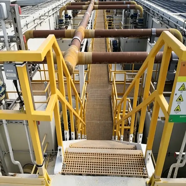 Yellow FRP handrail system and grating stairway installed on an industrial platform.